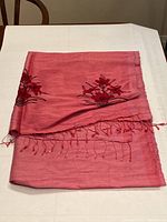 Folded view of the shawl highlighting the raw silk texture and fringe ends.