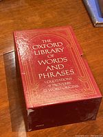 Red slipcase containing the three volume set with gold decorative borders and title.