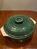 Top view of green lid on casserole with cream handles.