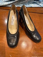 Top view of black leather women's shoes showing rounded square toe and Joseph Azagury label inside each shoe.