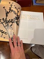 Open pages showing the title page of the book 'Fauna Britannica' by D Hart-Davis with decorative branch silhouette illustration.