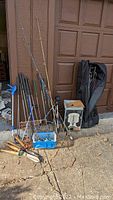 Set of fishing rods with reels, gardening tools including long-handled shovel, hand tools, and boxed coffee pot