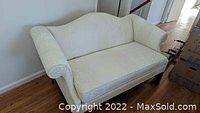 Photo of vintage off-white couch with elegant fabric pattern from the front left angle.