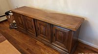 Side view of vintage solid wood buffet showing cabinet doors and wood finish.