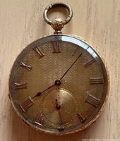 Front view of watch face showing guilloché dial, Roman numerals and small seconds subdial
