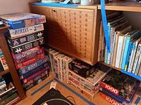 Stack of assorted puzzle boxes showing various brands and subjects including Ravensburger Birds, Piatnik puzzles, 49ers Baseball Memories, and others.