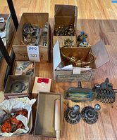 Wide view of multiple vintage bathroom hardware items including brass hooks, knobs, chrome posts, and other miscellaneous pieces.