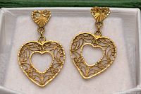 Front view of earrings on white background showing filigree heart design.