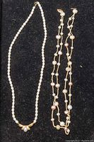 Photo shows two pearl choker necklaces side by side: one with white pearls and gold centerpiece, the other with multi-colored baroque pearls on gold chain.
