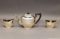 Front view of teapot, sugar bowl, and creamer on neutral background