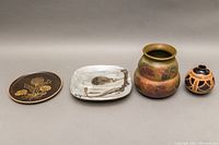 All 4 pottery pieces in a single line for scale and overview — two vases on right, two plates on left.