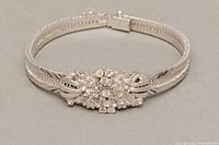 Front view of bracelet showing central floral cluster motif with clear stones