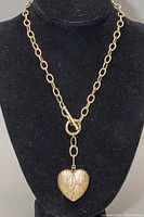 Front view of the gold-tone chainlink heart choker necklace displayed on black velvet.