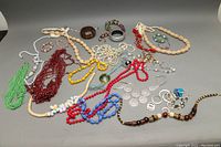 Photo showing assorted costume necklaces, bracelets and bangles spread out on a flat surface.
