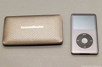Harman Kardon Esquire Mini speaker placed next to Apple iPod showing front views of both devices.