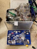 Three boxes and plastic organizer containing assorted costume jewelry mostly earrings in separate bags.