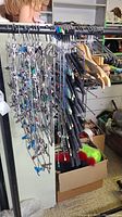 Photo showing mixed collection of metal hangers with multiple clips and wooden hangers on rack, surrounded by other items.