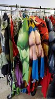 Photo showing Marvel superhero costumes hung on rack, mainly adult sizes, including green Hulk, Iron Man, Thor costumes.