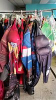 Photo of several Marvel superhero costume bodysuits hanging on a rack showing Iron Man, Captain America, and others.