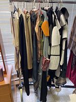 Image showing a rack with various Star Wars costumes including a Boba Fett costume with orange shoulder armor and other sci-fi outfits.