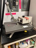 Full side view showing lever, platen and power cable on work surface