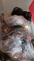 Wigs packed in plastic bags inside storage containers and crates, showing mixed colors and styles.