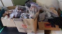 Three boxes of assorted wigs with various colors and styles, some in plastic bags