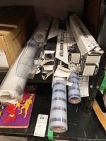 Photo showing multiple rolls of Funfox window film in various states of packaging, placed on a shelf alongside a box and book.