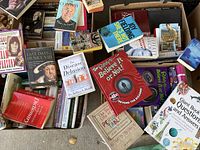 Overview of boxes with scattered books showing titles about biographies, reference books, and history.