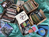 Four cardboard boxes filled with various used books, showing colorful spines of the LIFE Nature Library and other books.