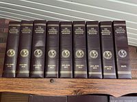 Photo of 9 maroon slip cases with gold embossed text including National Geographic magazines from 2010-2013 and one labeled MAPS.