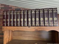 Full set of 14 brown slip cases with gold embossed National Geographic branding on spine, arranged on wooden shelf.