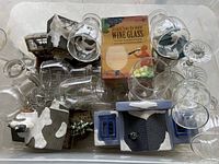 Collection of glassware items and four Christmas village houses arranged together, one house visibly broken and glued.