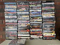 Stacked DVDs arranged in columns showing titles on cases. Various genres and titles visible including The Job, Resident Evil, Rocky Balboa, Gladiator, Super 8, and Peter Piper.