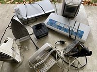 Overview photo showing 2 DVD players, 3 irons, Sony Disc player, iPod docking station and other small appliances.