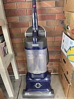Front view of blue and gray Kenmore upright vacuum cleaner showing full height and handle.