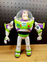 Front view of Buzz Lightyear toy showing detailed face, suit decals, and articulated arms and legs.