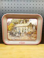 Front view of vintage Coca-Cola metal serving tray depicting Headley Inn scene with horse-drawn carriages and people. Tray measures approximately 13 by 10.5 inches.