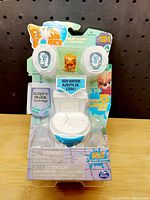 Front view of Flush Force Series 1 toilet toy in packaging showing branding and plush figures inside.