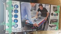 Boxed NHL air hockey table showing image of two players and branding.