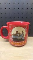 Side view of red Harry Potter Hogwarts Christmas mug with castle and holiday themed graphics