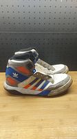 Left and right side view of the Adidas New York Knicks basketball shoes showing colors and wear.