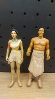 Front view of two Disney Pocahontas action figures against pegboard background.