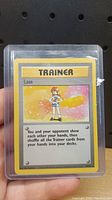 Front side of the Pokémon Trainer Lass card showing the character illustration, card title, description, and gameplay text.