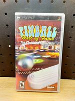 Front cover of the PSP game case showing the 'Pinball Hall of Fame: The Gottlieb Collection' title and artwork of pinball machine elements.