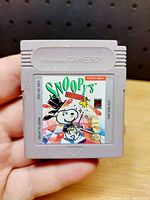 Front view showing label artwork featuring Snoopy as a magician and Nintendo Game Boy branding.