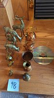 Photo showing all bronze deer and mice figurines alongside copper pots and teapots with CD for scale.