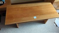 Top view of a solid wood coffee table showing the natural wood grain surface and condition of the tabletop