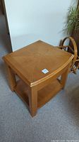 View of the square wooden end table showing geometric pattern on top, shelf at bottom, and solid legs.