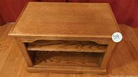 Front view of solid wood TV stand with shelf showing wood grain and craftsmanship.